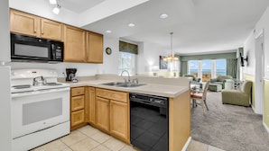 A modern kitchen with wooden cabinets, a microwave, stove, and dishwasher. - A Place at the Beach - Windy Hill (North Myrtle Beach)