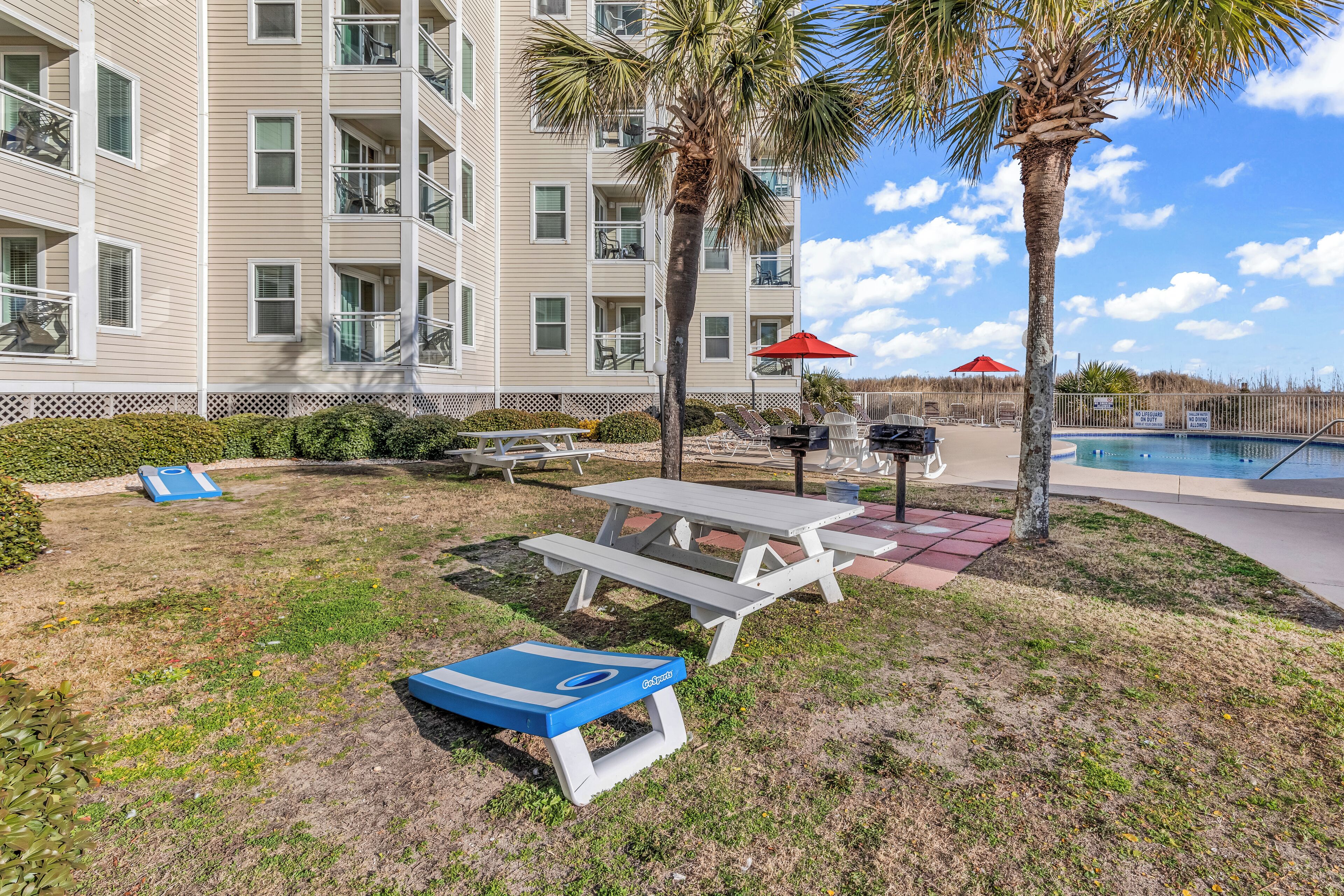 A poolside area with a picnic table, lounge chairs, and a small pool.