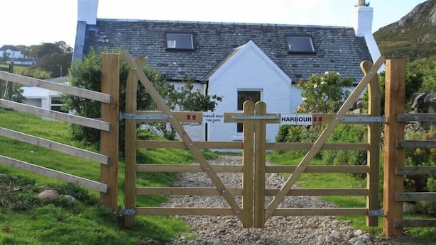A wooden gate with a sign that reads "Please shut the gate" and "Harbour". - Harbour (Isle of Colonsay)