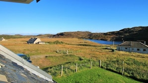A rural landscape with a lake, houses, and a clear sky.