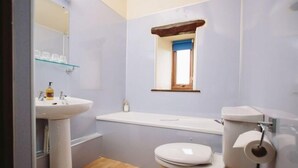 A bathroom with a pedestal sink, a toilet, and a window above the sink. - Garth Cottage (Hot Tub) (Brampton)
