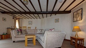 A cozy living room with a wooden ceiling, a sofa, a coffee table, and a lamp. - Gelt Cottage (Hot Tub) (Brampton)
