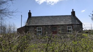 A stone house with a gabled roof and two chimneys. - Little Dunbar (Dumfries)