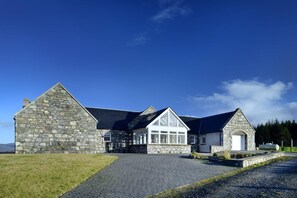 A stone building with a large entrance and a covered porch. - Mountain View Lodge 375948 (Kingussie)