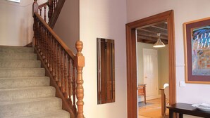 A staircase with wooden balusters, a door with a mirror, and a table with papers. - 10 Murray Park  375840 (St. Andrews)