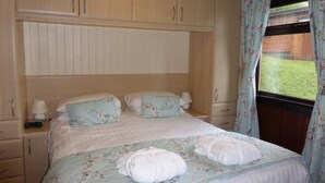 A bedroom with a bed, two bedside tables, a window with curtains, and a wooden wardrobe. - Birch 22 With Hot Tub, Newton Stewart (Newton Stewart)