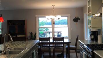 A modern kitchen with a central island, built-in appliances, and a dining area with a view.