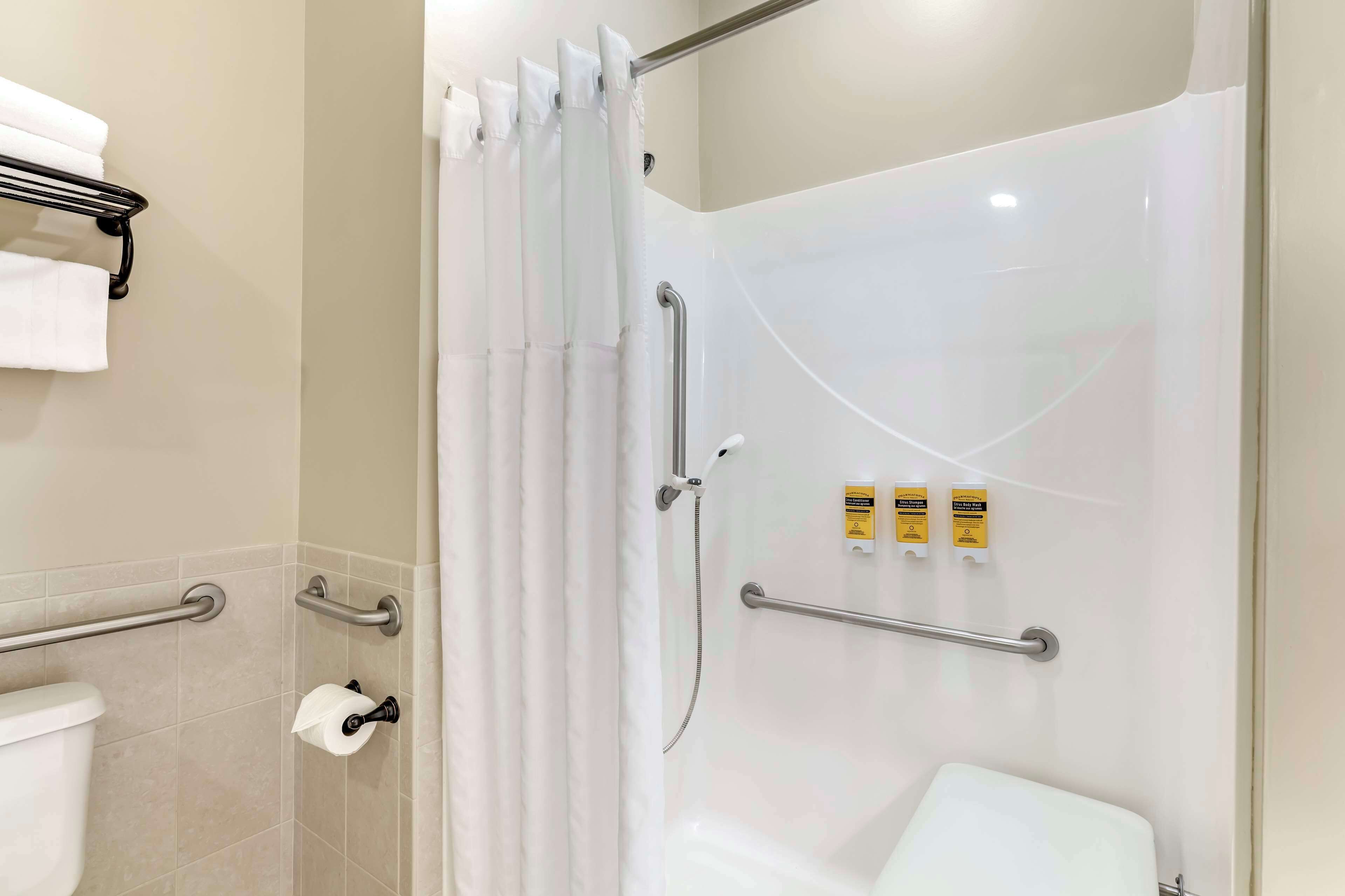 Un baño moderno con ducha, inodoro y toallero.
