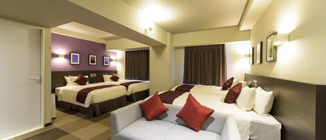 A hotel room with two beds, a sofa, and a large mirror.