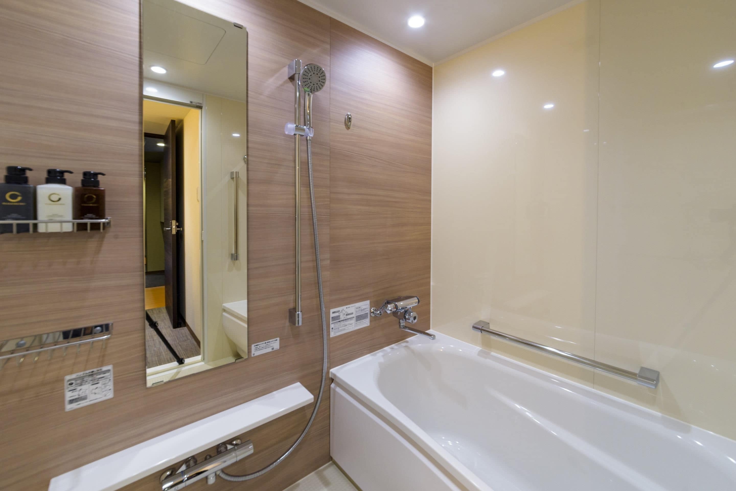 A modern bathroom with a bathtub, a shower, and a large mirror.