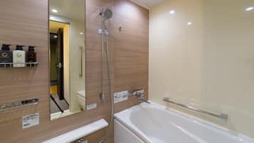 A modern bathroom with a bathtub, a shower, and a large mirror.