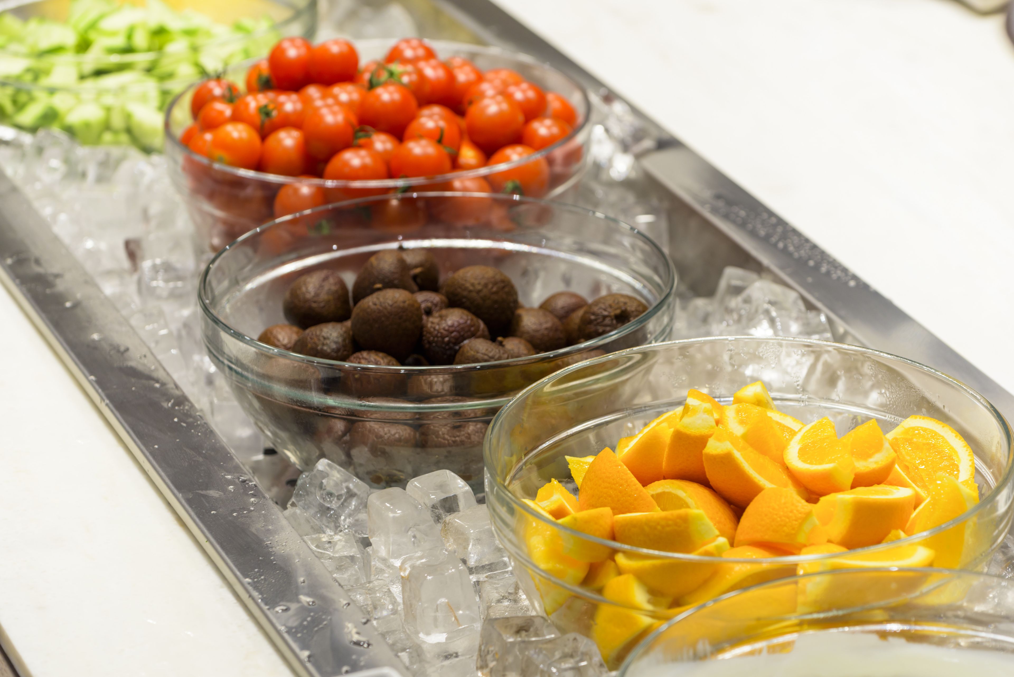 Un buffet proposant une variété de fruits et de légumes présentés sur des plateaux réfrigérés.