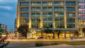 A multi-story hotel with a modern design, featuring balconies and a well-lit facade. - Zeus Essence Wyndham Athens Residence (Athens)