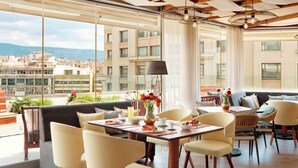 A modern dining area with a view of the cityscape. - Zeus Essence Wyndham Athens Residence (Athens)