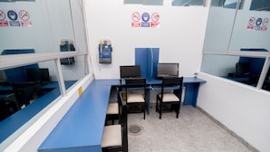 A room with a long blue counter, several computer stations, and chairs. - Hotel Sol de Piura (Piura)