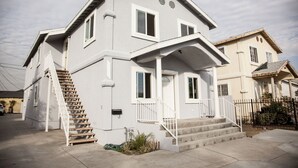 A two-story house with a front porch, a staircase, and a small garden area. - Los Angeles Extended Stay Hostel (Los Angeles)