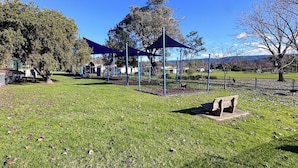 A park with a playground, a covered seating area, and a stone bench. - Pether Cottage - Talbingo NSW (Talbingo)