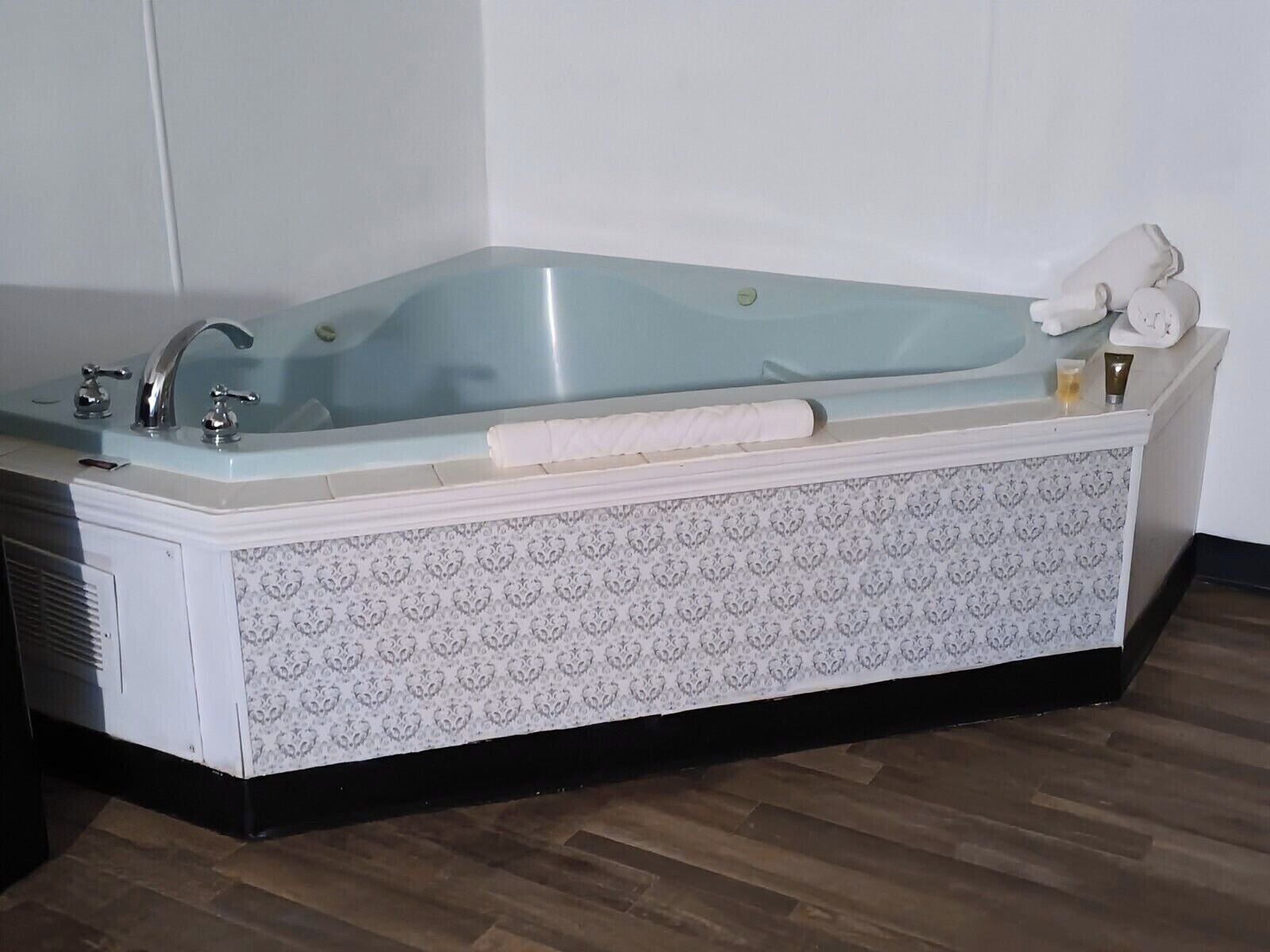 Een badkamer met een vrijstaand bad, een handdoekhouder en een toilet.