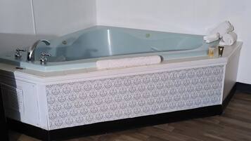 Een badkamer met een vrijstaand bad, een handdoekhouder en een toilet.