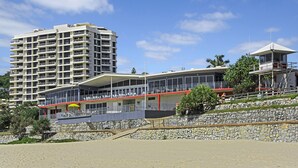Un hôtel situé en bord de mer, doté de nombreux balcons, d’un espace couvert et d’une tour de surveillance pour les sauveteurs.