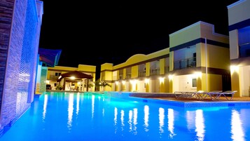 Una piscina al aire libre, sillones reclinables de piscina