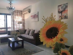Una sala de estar con sofá, una mesita de centro y una gran decoración de girasol.