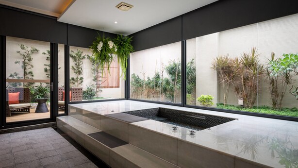 A modern interior with a large window, a seating area, and a water feature. - Shu Shia Motel (Taichung)