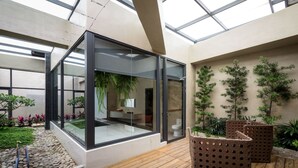 A modern bathroom with a glass enclosure, wooden flooring, and potted plants. - Shu Shia Motel (Taichung)