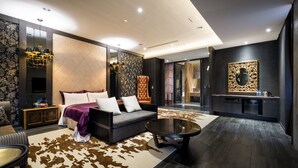 A modern hotel room with a large bed, a sofa, a coffee table, and a dining area with a dark wood finish. - Shu Shia Motel (Taichung)