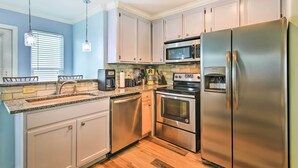 A modern kitchen with stainless steel appliances, white cabinets, and a granite countertop. - Near Port Aransas Beach: Condo w/ Pool Access (Port Aransas)