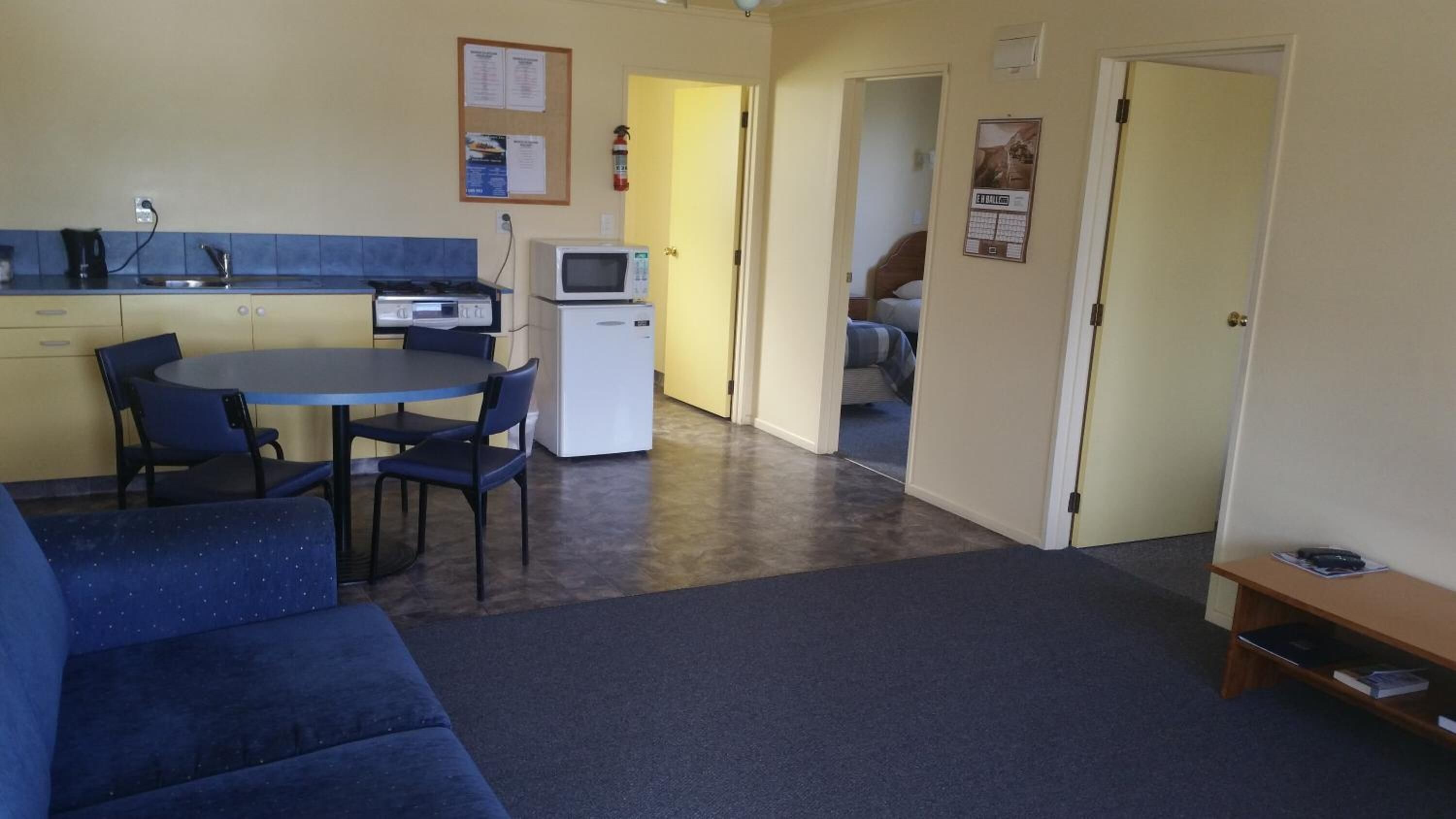 A compact living space with a kitchenette, a dining area, and a small seating area.