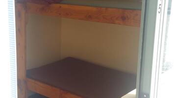 A bunk bed room with a single bed on the top bunk and a lower bunk.