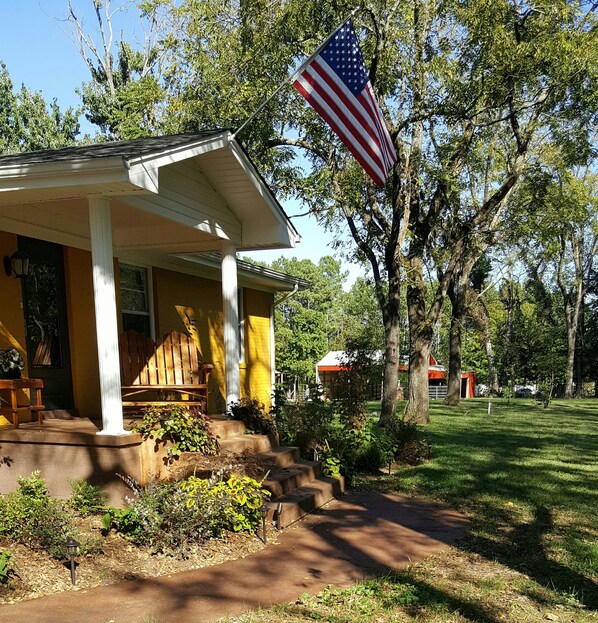 Stroll onto the inviting porch of this charming single-story home, surrounded by a lush lawn and mature trees.