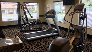 A gym with treadmills, elliptical machines, and a stationary bike.