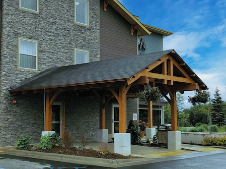 A building with a stone facade, wooden porch, and a sign indicating a fire department connection.