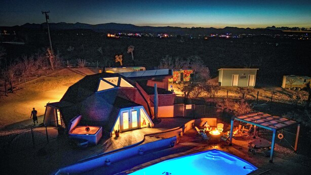 A residential property with a swimming pool, outdoor seating area, and a small deck.