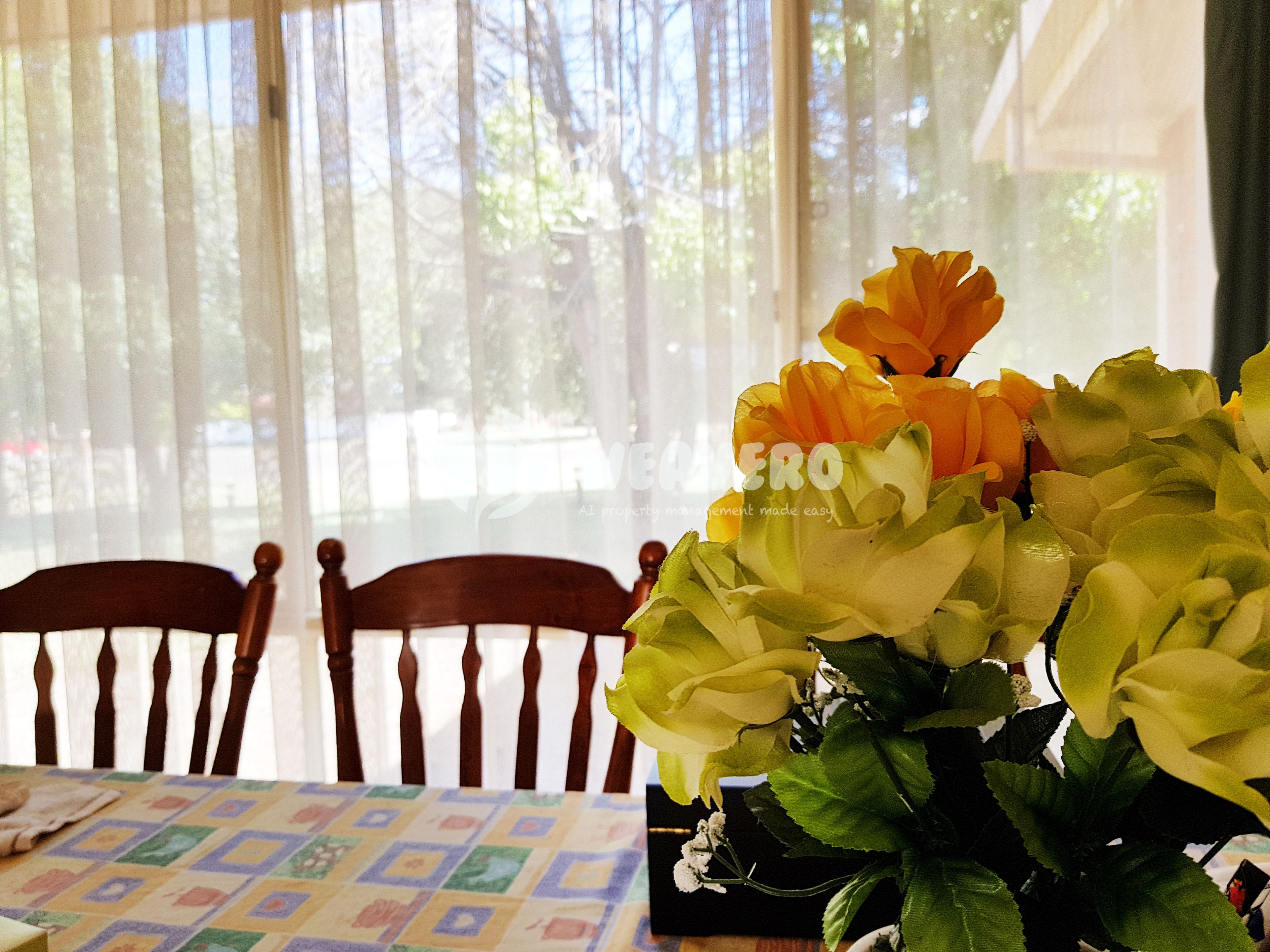 A table with a floral arrangement and a patterned tablecloth.