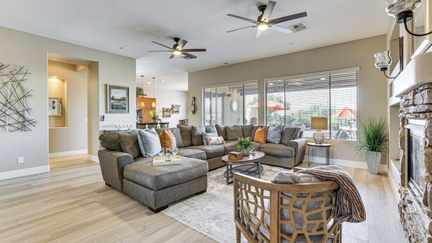 A spacious living room with a sectional sofa, a wooden coffee table, and a ceiling fan. - Pool, Hot Tub & Golf Course View! ‘Anthem Oasis’ (Anthem)
