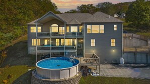 Uma casa de dois andares com um amplo quintal, piscina e um deck.