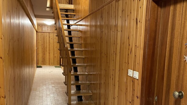 A wooden interior with a staircase leading to an upper level.