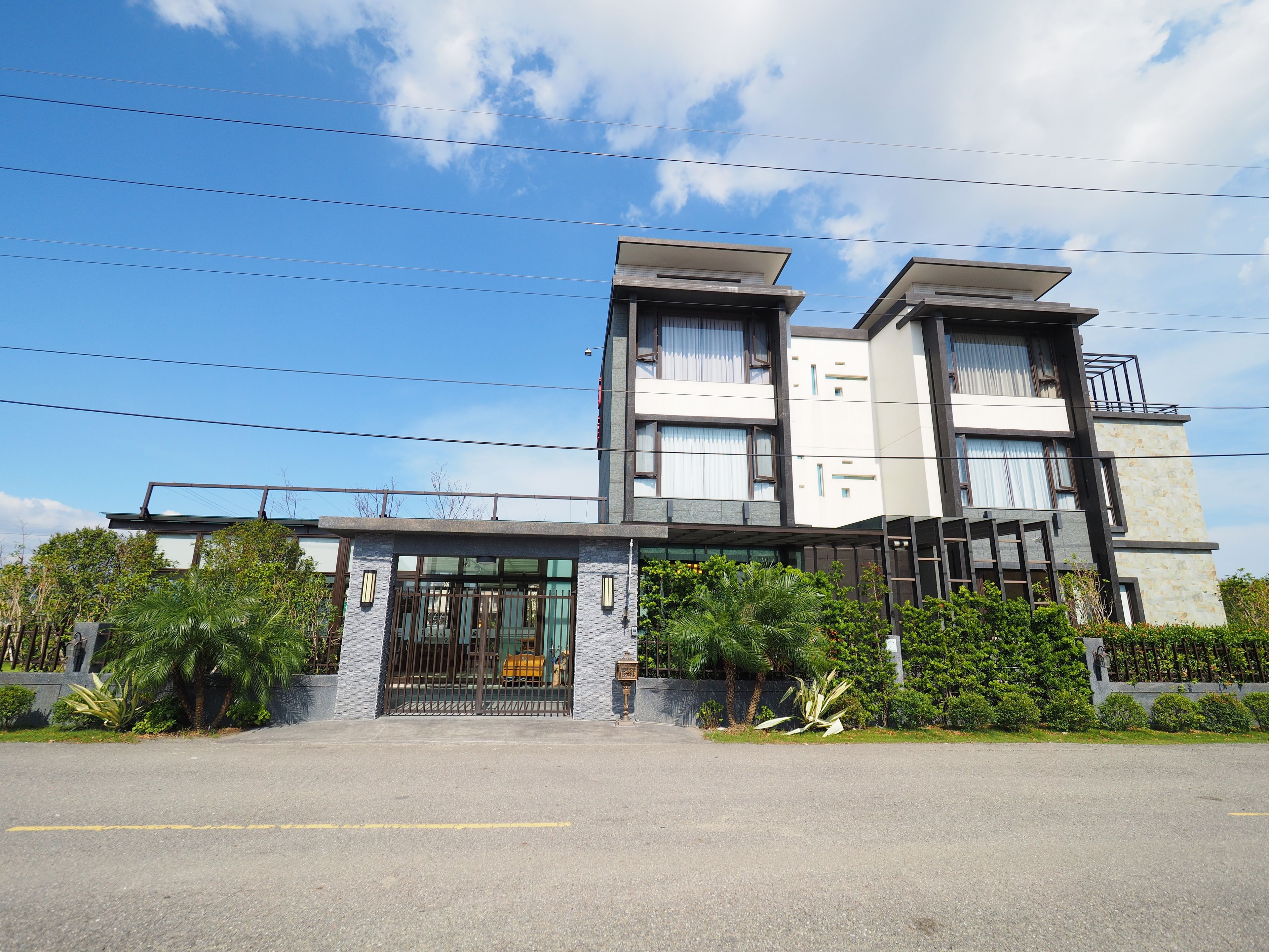A modern two-story building with a flat roof and large windows.