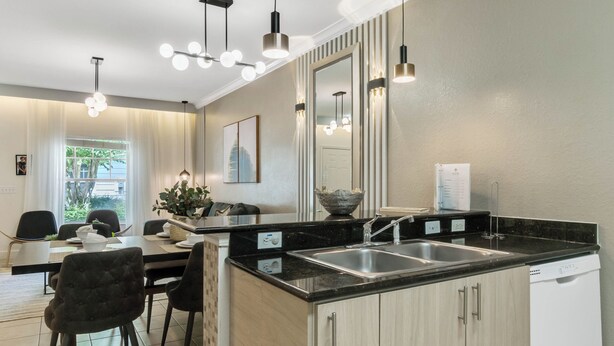 A modern kitchen with a central island, stainless steel sink, and pendant lighting. - 3 BD/ 2 BA/ Lucaya Village (6-107) (Kissimmee)