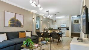 A modern living room with a sofa, coffee table, and dining area. - 3 BD/ 2 BA/ Lucaya Village (6-107) (Kissimmee)