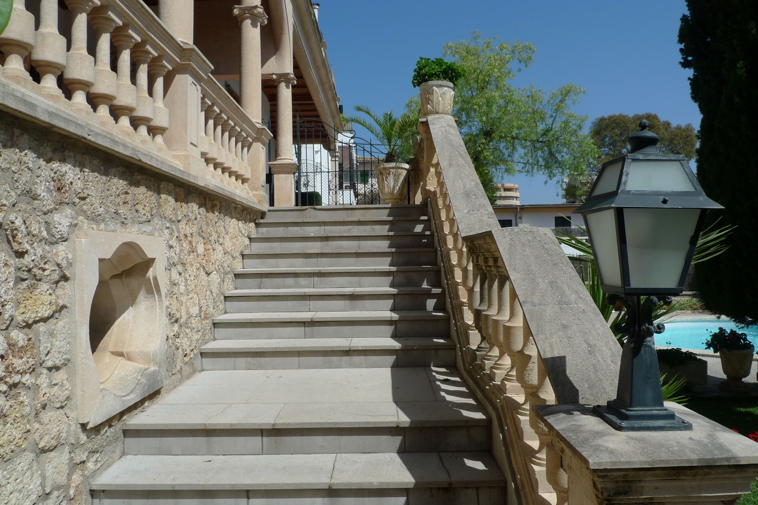 A stone staircase with ornate balustrades leading to a building entrance.