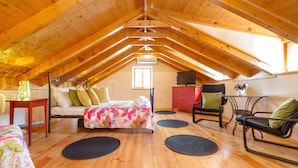 A cozy attic bedroom with a wooden ceiling, a bed with floral bedding, a desk, and a chair. - Authentic Stone Villa In The Heart Of Split, Next To Diocletian's Palace  (Split)