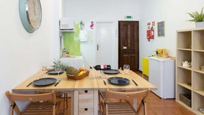 Una cucina compatta con un tavolo da pranzo per due persone, un forno a microonde e un piccolo frigorifero.