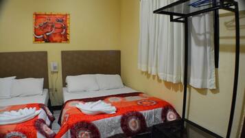 A hotel room with two beds, a headboard, a curtain, and a wall-mounted towel rack.
