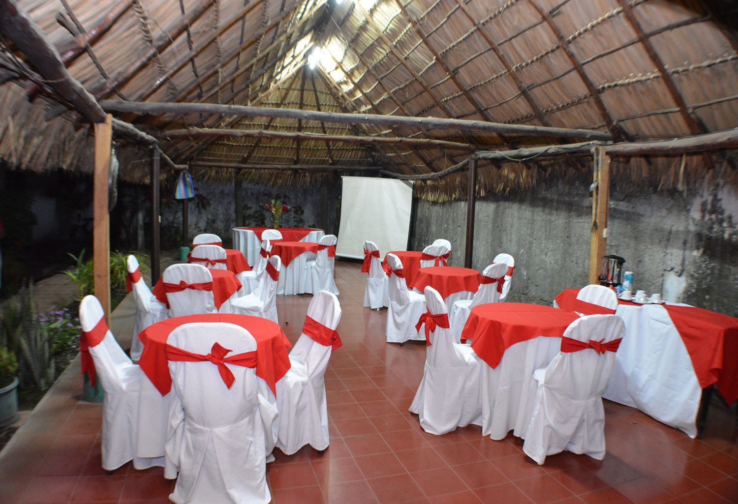 A covered outdoor area with tables and chairs arranged for an event.