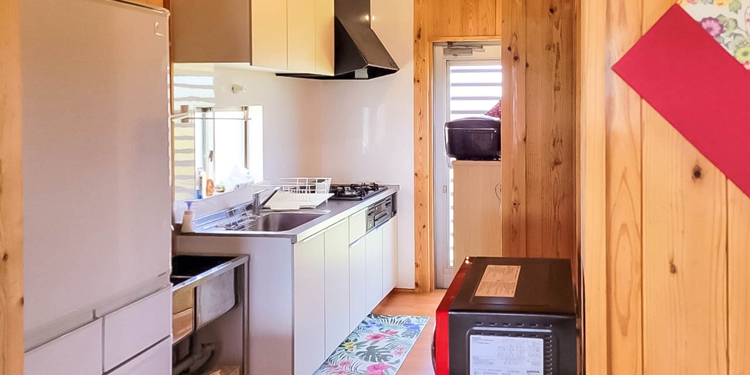 Una cocina compacta con refrigerador, estufa y lavamanos.