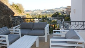 A terrace with white furniture, including sofas and a table, overlooking a scenic hillside view. - Beautiful Detached Spacious Villa, Amazing views, Private Heated Pool, WiFi, A/C (La Manga Club)